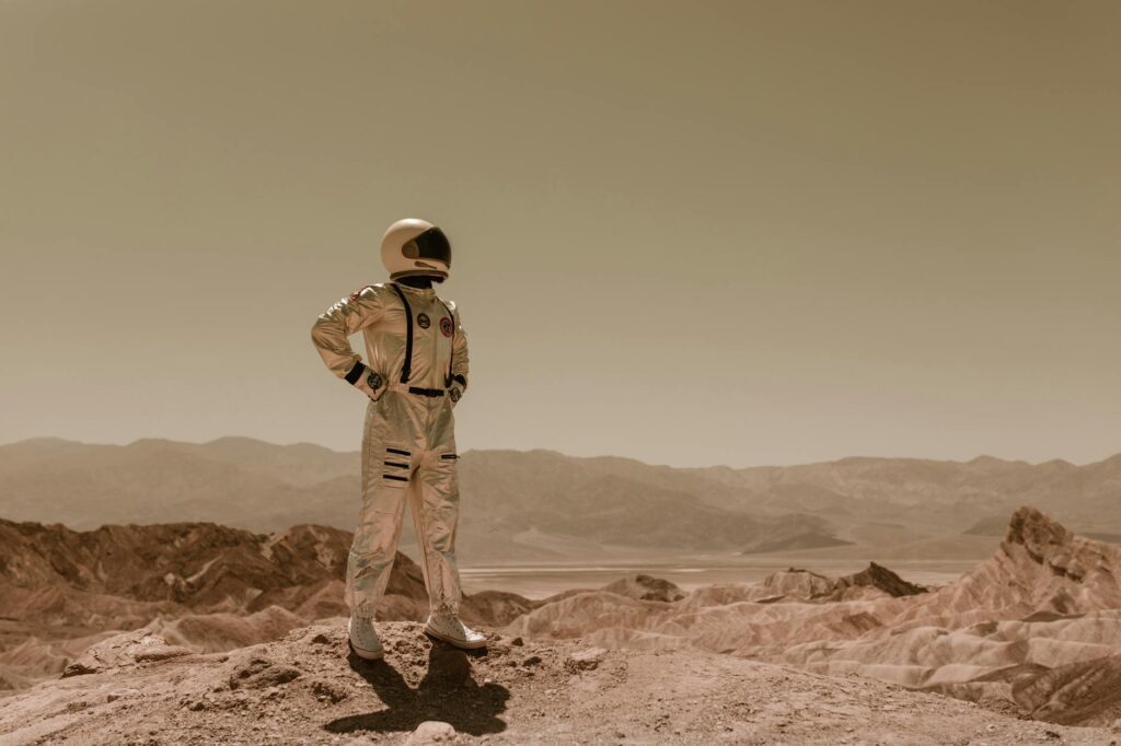 Astronaut standing in a desolate landscape, evoking sci-fi exploration on another planet.